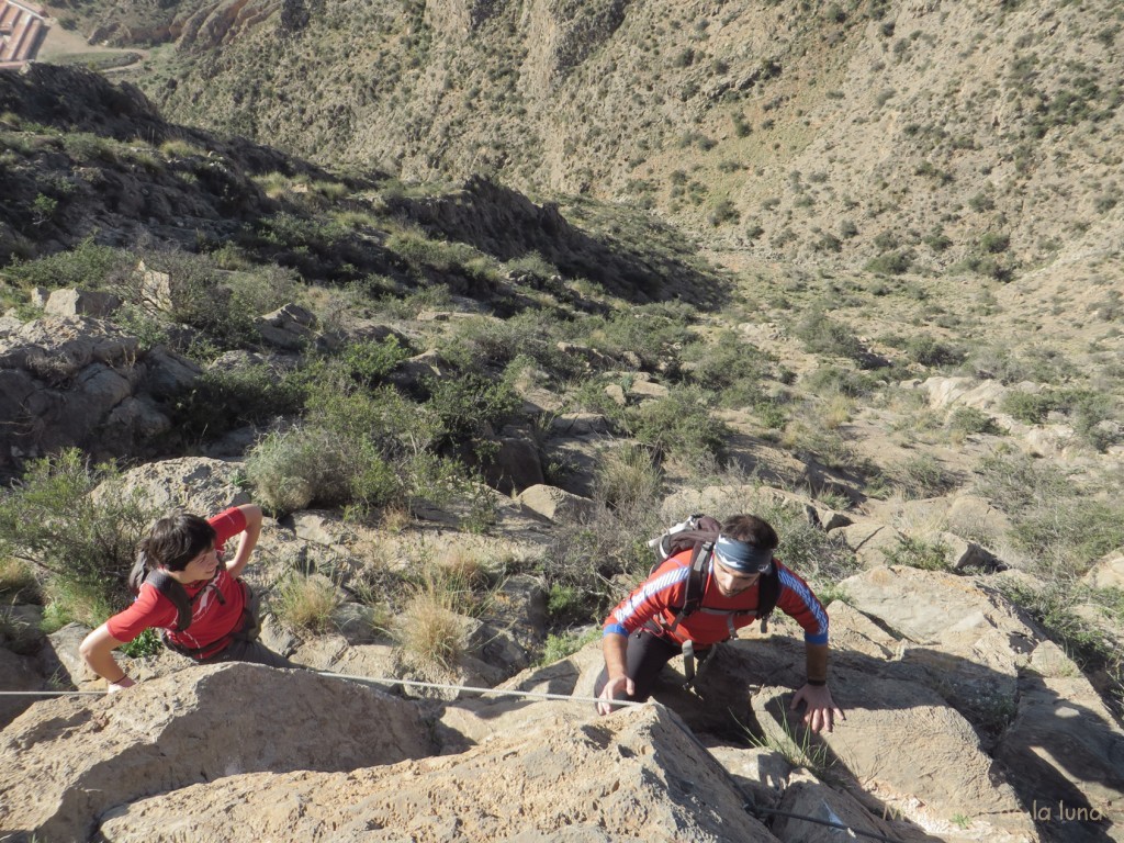 Nuria y Vicente en el paso con cable de la cresta. Abajo el Barranco del Cementerio