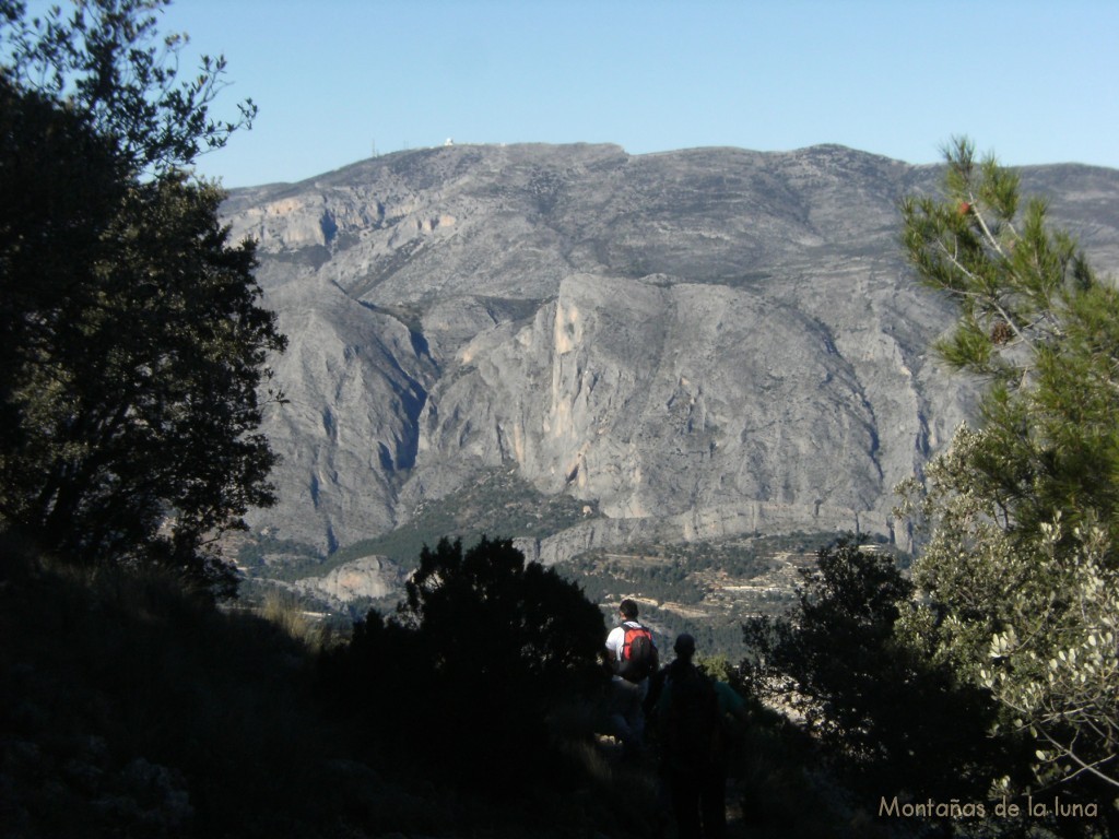 Bajando se aprecia la cima de Sierra Aitana y bajo ésta el Peñón Divino de Sella