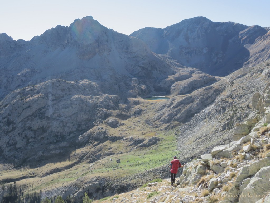 Pau bajando a la senda marcada con la Tuca del Cierco a la izquierda, Cabo de Comaguana a la derecha, el Ibón dels Chuncos en el centro y abajo la Cabaña de Pardines