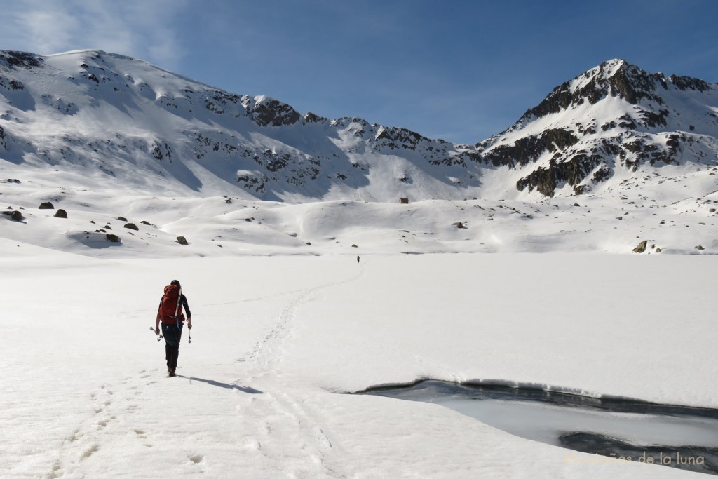 Roberto cruzando el Estany Gran d'Anglios con la Collada d'Anglios al fondo