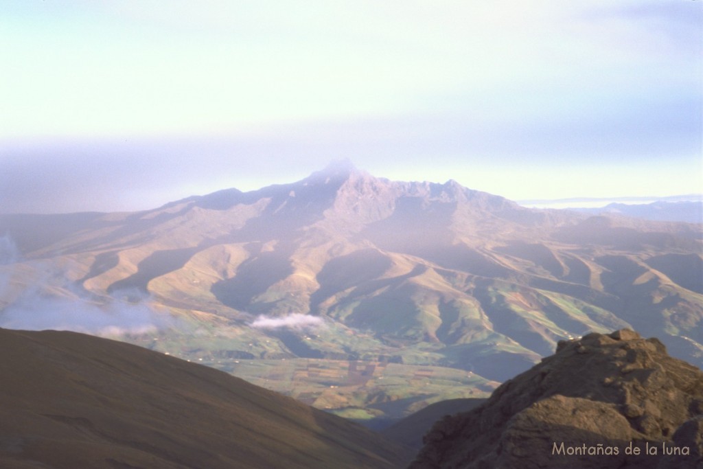 El Carihuayrazo desde la cima del Igualata, con la nube de cenizas del Tungurahua cubriendo la picuda cima