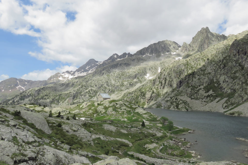 Delante el Ibón de Bachimaña Inferior y el Refugio de los Ibones de Bachimaña, y arriba de izquierda a derecha: Argualas, Garmo Negro, Pico de Pondiellos y Pico de Los Arnales