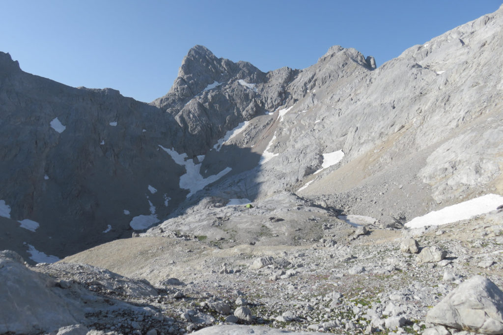 Jou del Cerredo con las pendientes del TorreCerredo a la derecha y al fondo la Torre Coello a la derecha y el Tiro del Oso, el más espectacular, a la izquierda. A la izquierda de éste, la Horcada de Don Carlos. En el centro casi inapreciable la verde tienda de la pareja de montañeros acampados.