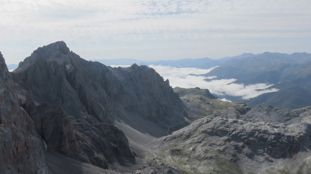 Peña Vieja a la izquierda, la Torre de Las Coteras Rojas delante de ésta y Peña Olvidada en el centro. Abajo el camino que va a El Cable y a la derecha el corte del circo de Fuente De con el valle de La Liébana bajo las nubes