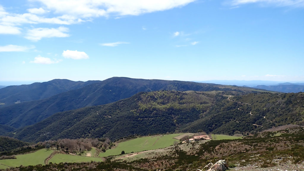 Subiendo al Matagalls delante la Fageda de La Cortada con El Cucurull, justo detrás en el centro el Puig Drau, a la derecha la pista y llano del Pla de La Calma, y al fondo izquierda el Turó de Samon. Abajo Santandreu de La Castanya.